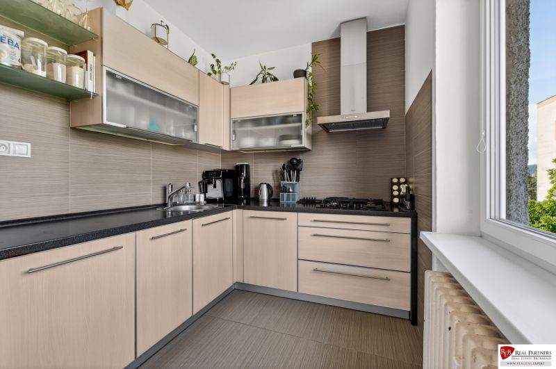 A kitchen in a 3-room apartment with light furniture and built-in appliances.