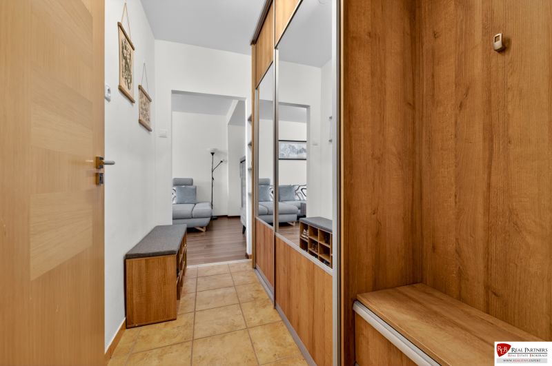 Entrance hall in a 3-room apartment with built-in mirrored wardrobes and a floor with a wooden decor.