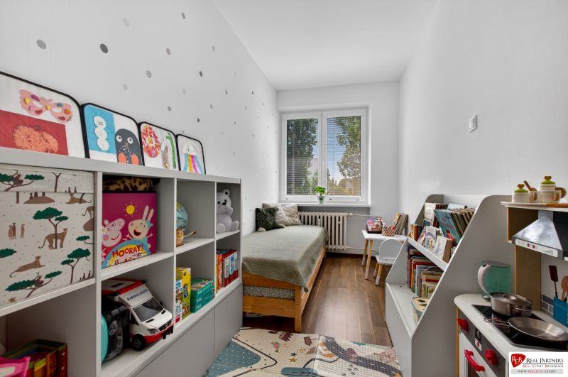 Children's room with a bed, bookshelves, and a floor with a wooden decor, 3-room apartment.