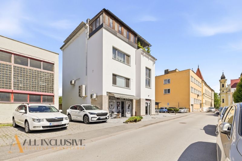Exterior of a building with commercial spaces in Galanta, SNP district. Parking spaces in front of the building.