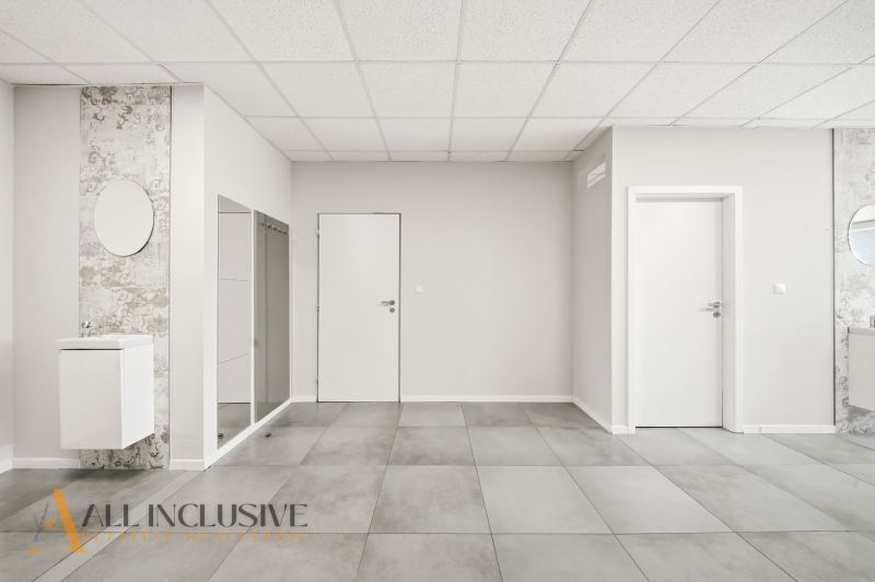 Interior of commercial spaces with tiles and sinks on light walls.