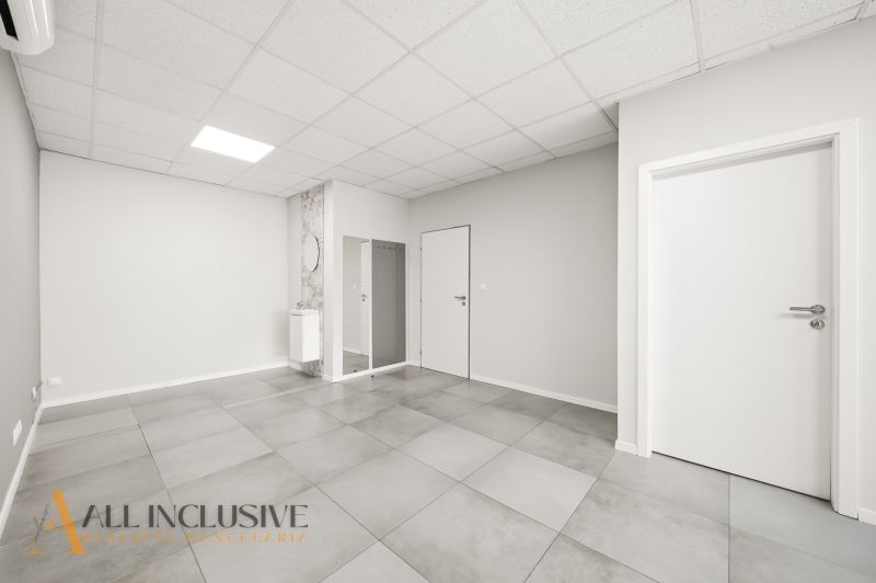 Bright commercial spaces with gray flooring and white doors.