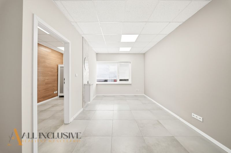 Spacious commercial spaces with light walls and tiles, featuring wooden decor.