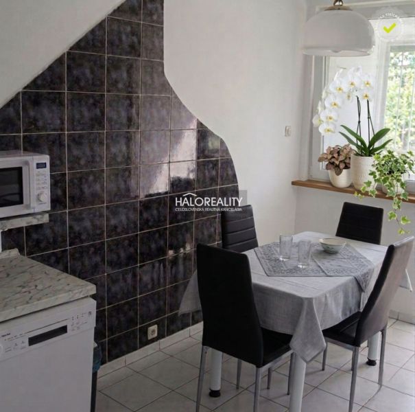 Dining area in a 3-room apartment with a modern table and tiles on the wall.