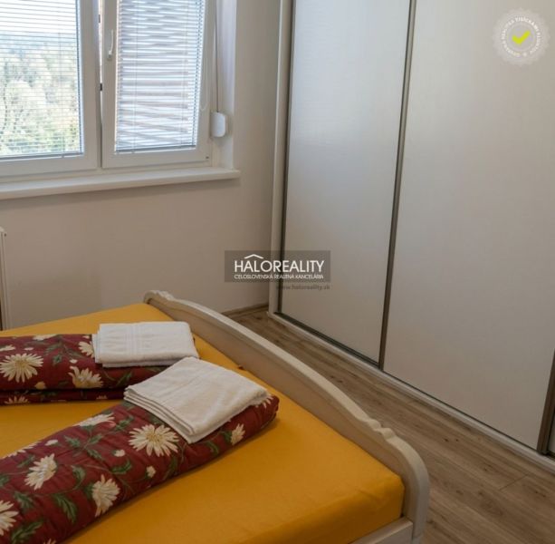 A bedroom with a bed, built-in wardrobe, and wooden decor flooring in a 3-room apartment.