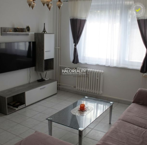 Living room in a 3-room apartment with white walls and a TV on the wall.