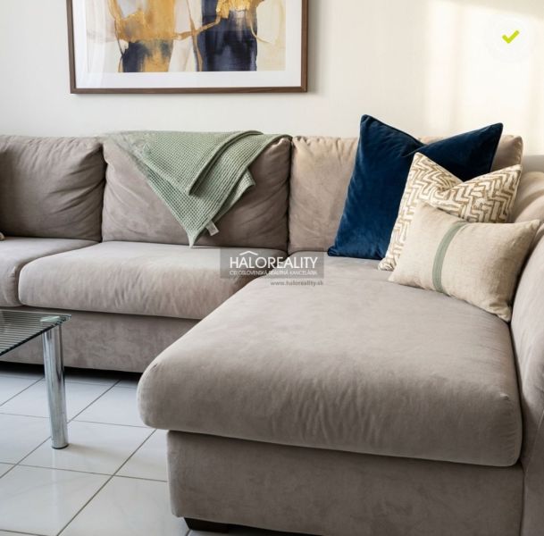 A comfortable sofa in a 3-room apartment, complemented by decorative pillows and a painting on the wall.