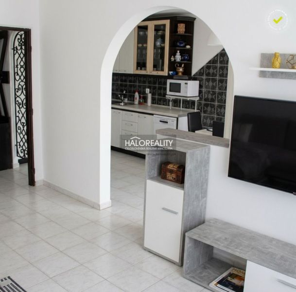 A kitchen with white furniture and black and white tiles in a 3-room apartment.
