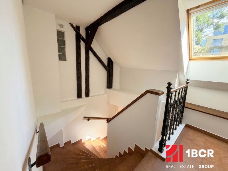 Interior with wooden staircase and large window in a 2-room apartment.