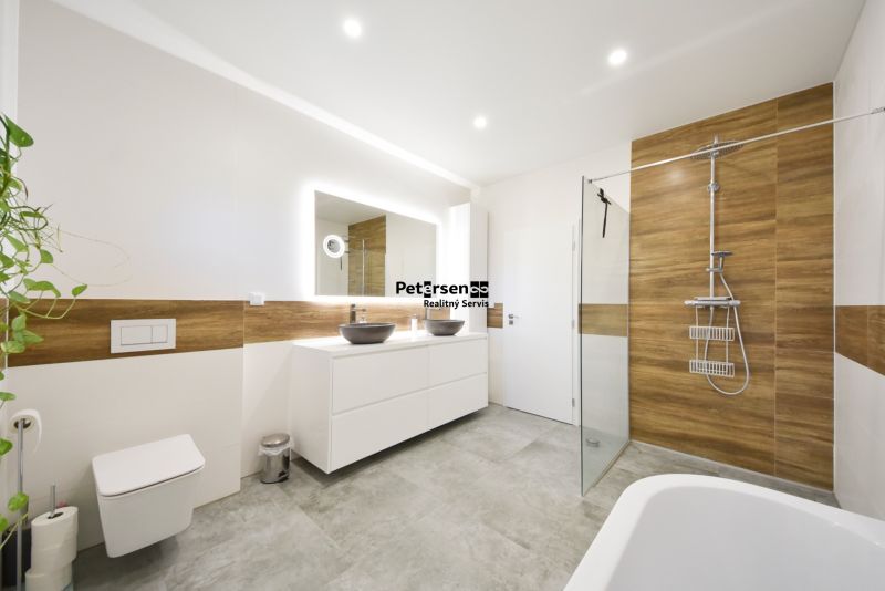 A bathroom in a family house with brown wooden decorations and two sinks.