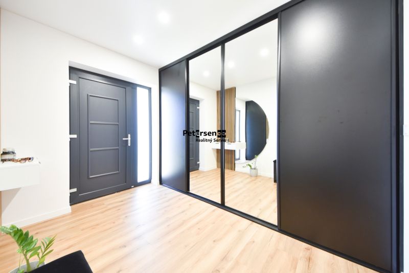 Interior of a family house with black doors and a wooden decor floor.