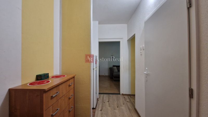 Hallway with a cabinet, wooden decor flooring, entrance to a 2-room apartment.