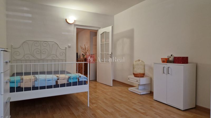 Bedroom with a white bed and storage space, floor with wood decor.