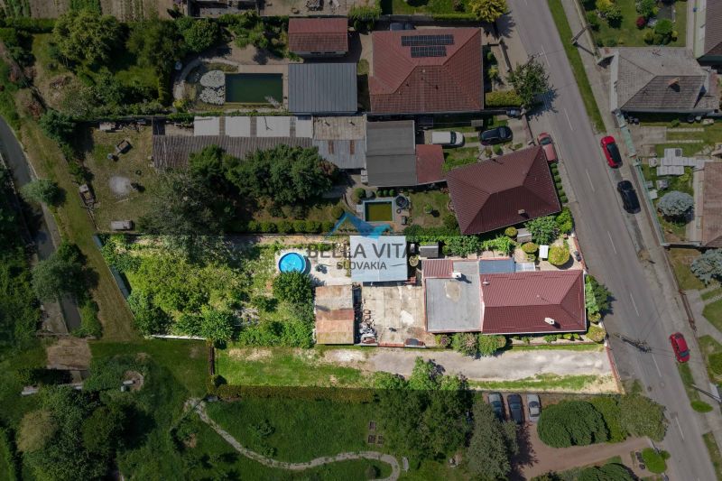 Aerial view of a family house in Topoľnica on Topoľnica Street with a garden and a swimming pool.