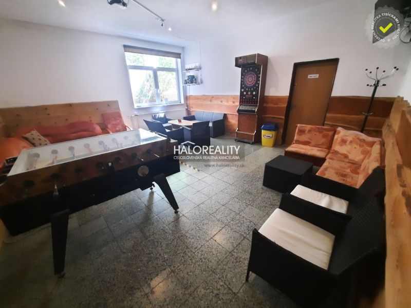 Gastro premises with seating, table football, and darts, floor with wooden decor.