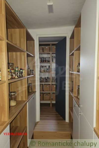 The cottage has a pantry with shelves featuring a wooden decor and storage baskets.