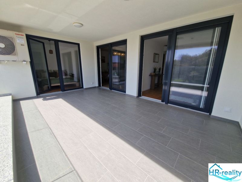 A spacious terrace with tiles in a 3-room apartment in Povljana.