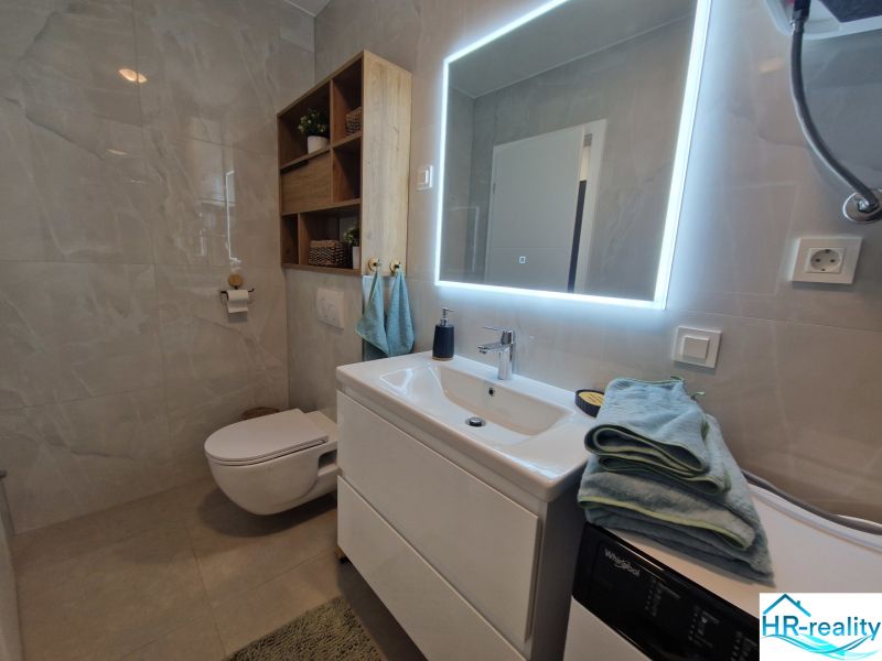 Bathroom in a 3-room apartment with a large mirror and cabinets.