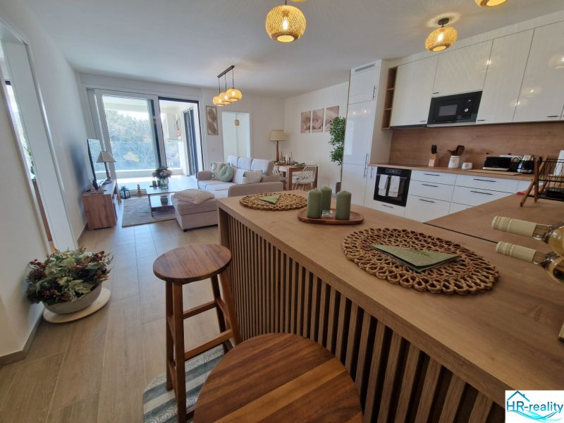 A bright kitchen and living room in a 3-room apartment with a wooden decor floor.