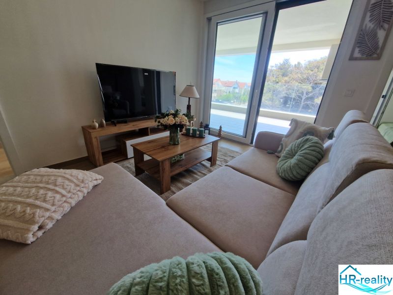 Living room in a 3-room apartment with a large sofa and a television.