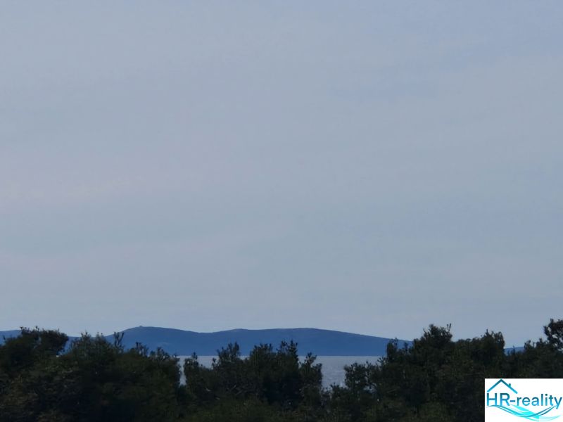 A view of the island and the sea through the trees in Povljana, ideal for a 3-room apartment.