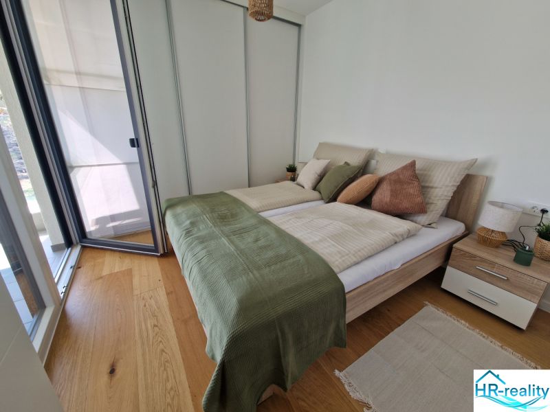 A bedroom with light furniture and a wooden decor floor in a 3-room apartment.