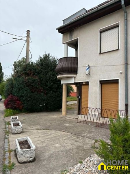 Commercial premises on Práce Street, Komárno with a terrace and flower pots in front of the building.