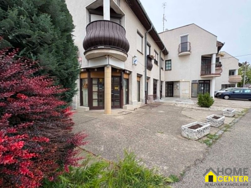 Commercial premises on Práce in Komárno with greenery and parking spaces.