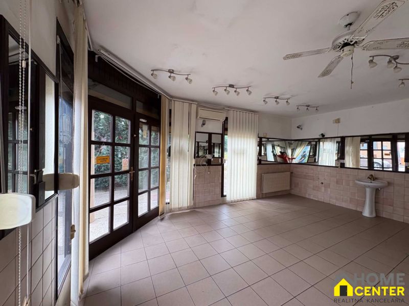 Interior of commercial premises with tiles, mirrors, and a sink.