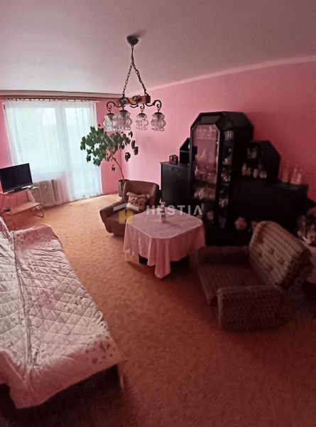 Living room with pink walls and comfortable seating in a 3-room apartment.