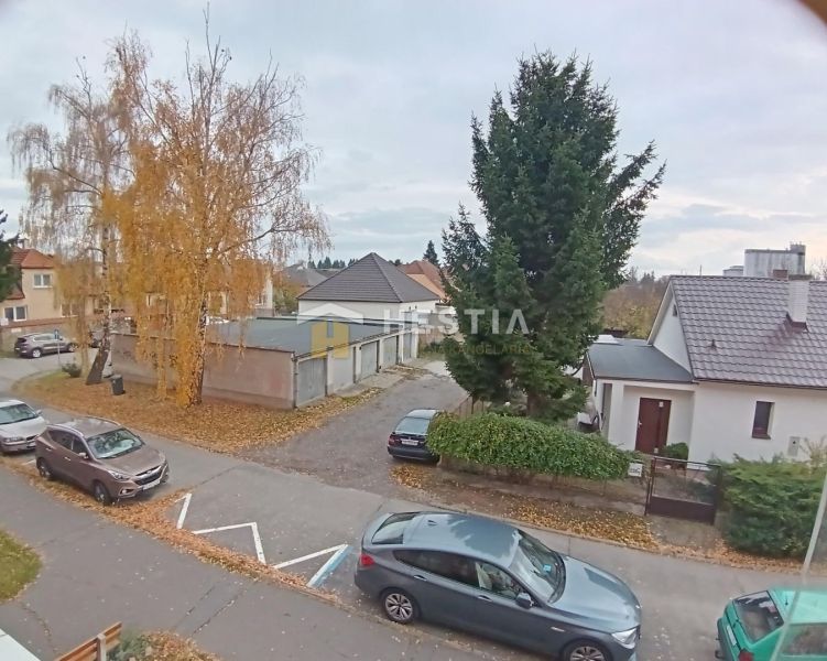 Autumn view of the street in Senica, showing trees and parked cars in front of a 3-room apartment.