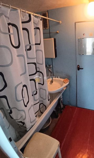 A bathroom with a shower curtain and a mirror in a 3-room apartment.