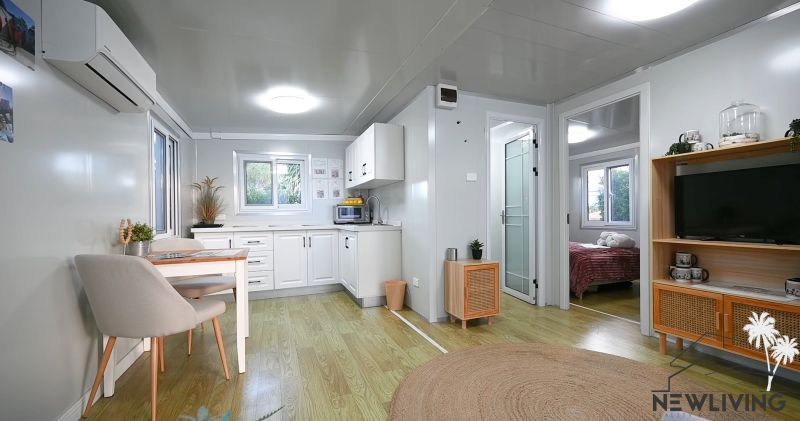 Interior of a family house with a wooden decor floor, kitchen, and dining table.