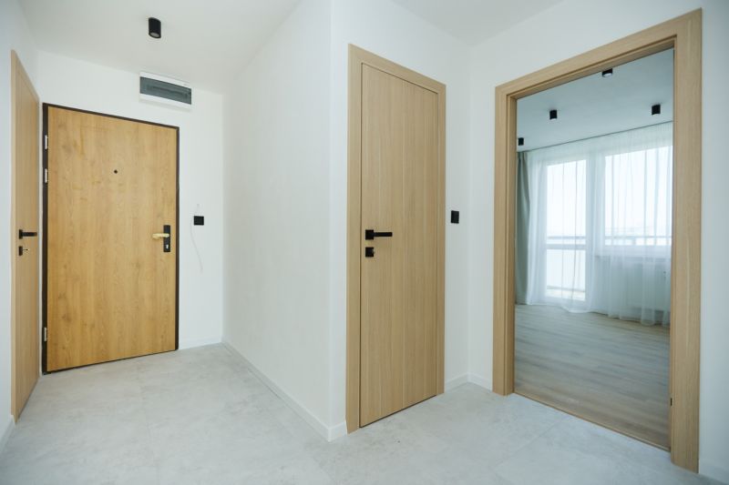 A bright hallway with light doors and a wooden decor floor in a 4-room apartment.