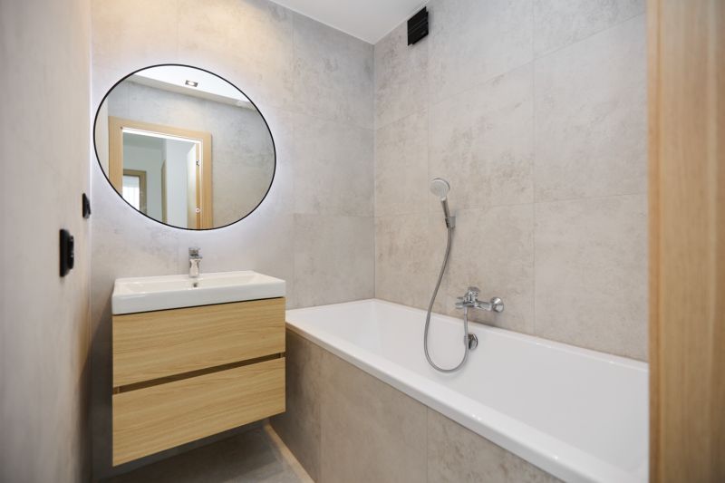 A bathroom with a bathtub and a sink in a 4-room apartment with wooden decor.