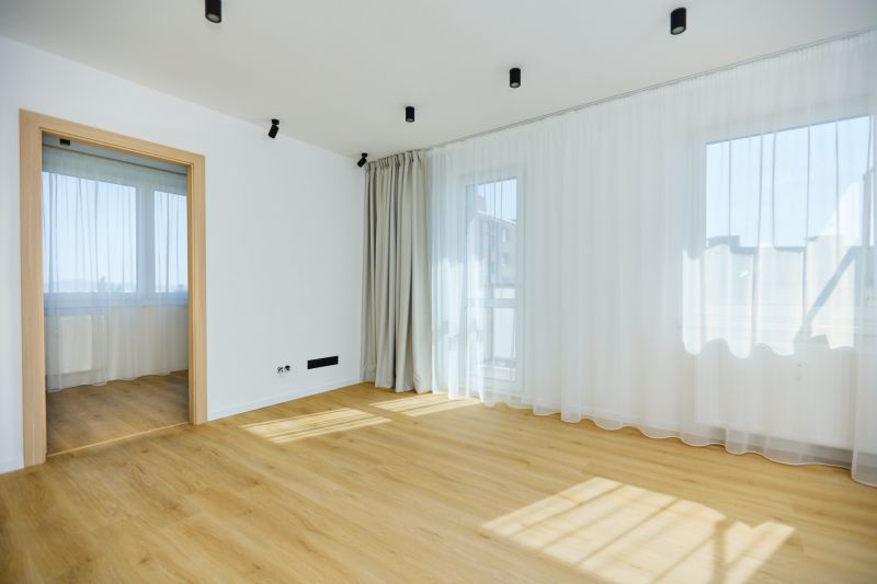 Living room in a 4-room apartment with a wooden decor floor and white curtains.