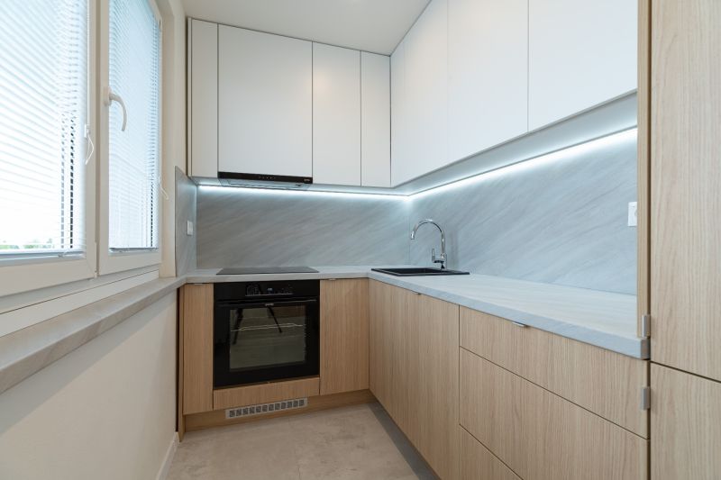 A kitchen in a 4-room apartment with a wood-patterned floor and sleek design.