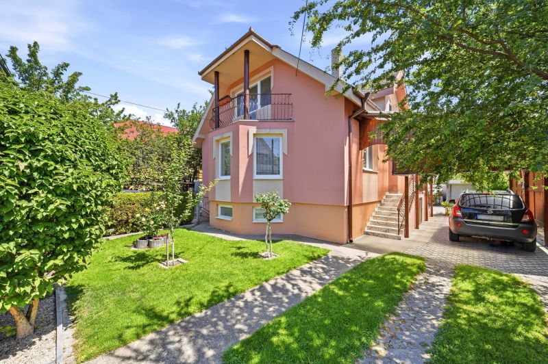 A family house in Gabčíkovo with a landscaped garden, parking, and trees.