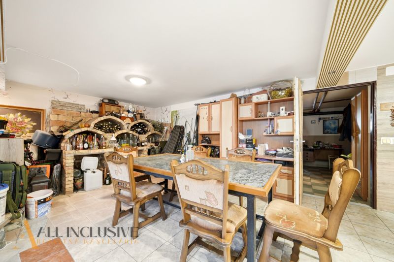 A dining room in a family house with a dining table, wooden chairs, and a burgundy wall.