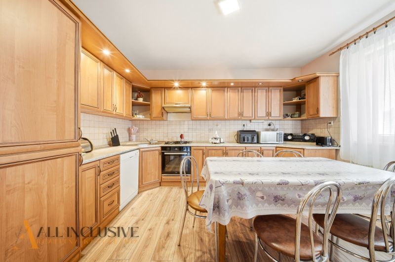 A kitchen with wooden decor and a large dining table in a family house.