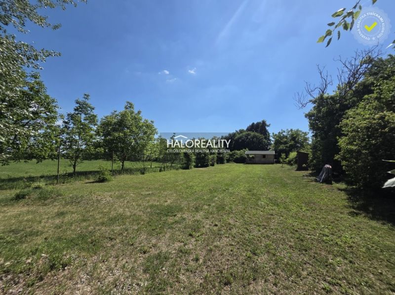 A spacious green plot in Potônske Lúky surrounded by trees, ideal for living.