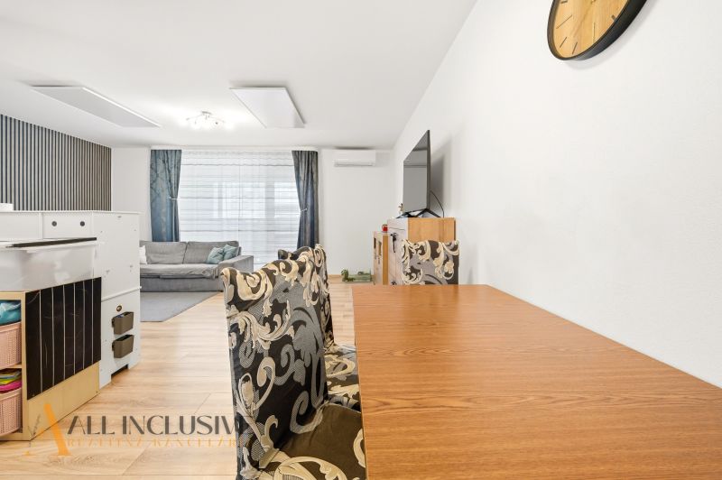 A dining room with a wooden decor floor and stylish chairs in a 3-room apartment.