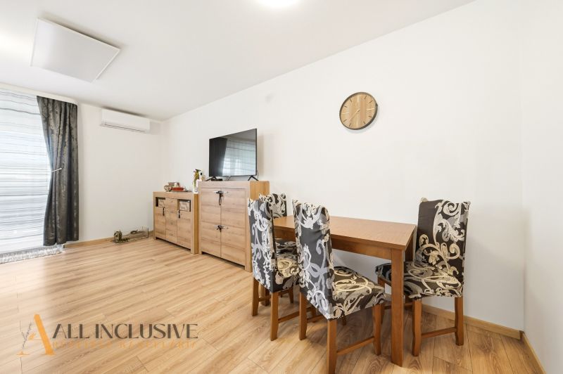Dining nook in a 3-room apartment with decorative furniture and wood-patterned flooring.