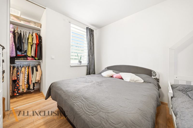 Bedroom in a 3-room apartment with storage space and a bed, floor with wooden decor.
