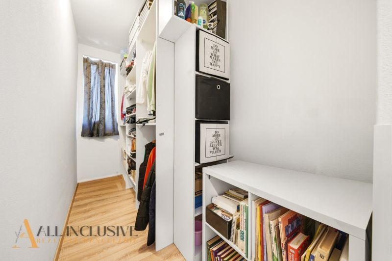 Storage space in a 3-room apartment with shelves and flooring with a wood decor.