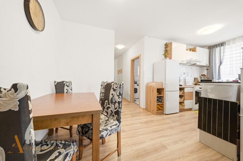 Kitchen and dining area in a 3-room apartment with a wooden decor floor.