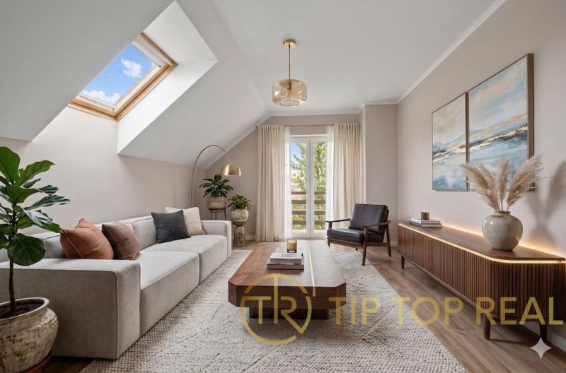 Elegant living room of a family house with a skylight, large sofa, and decorative plants.