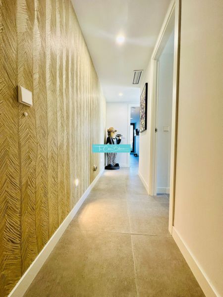 A hallway in a 3-room apartment with a textured wall and tiled floor.