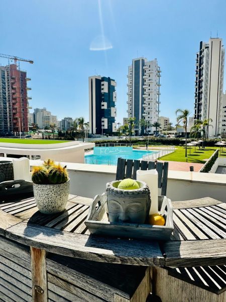 A balcony of a 3-bedroom apartment in Calpe with a view of the pool and high-rise buildings.