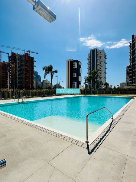 A pool surrounded by buildings in Calpe, ideal for a 3-bedroom apartment with modern amenities.